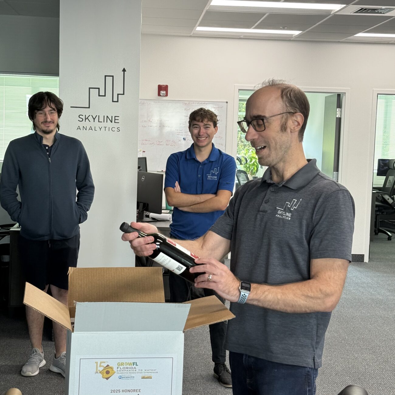 The Skyline Analytics team and Chris Pumo, CEO unboxing the GrowFL Florida Companies to Watch celebration box